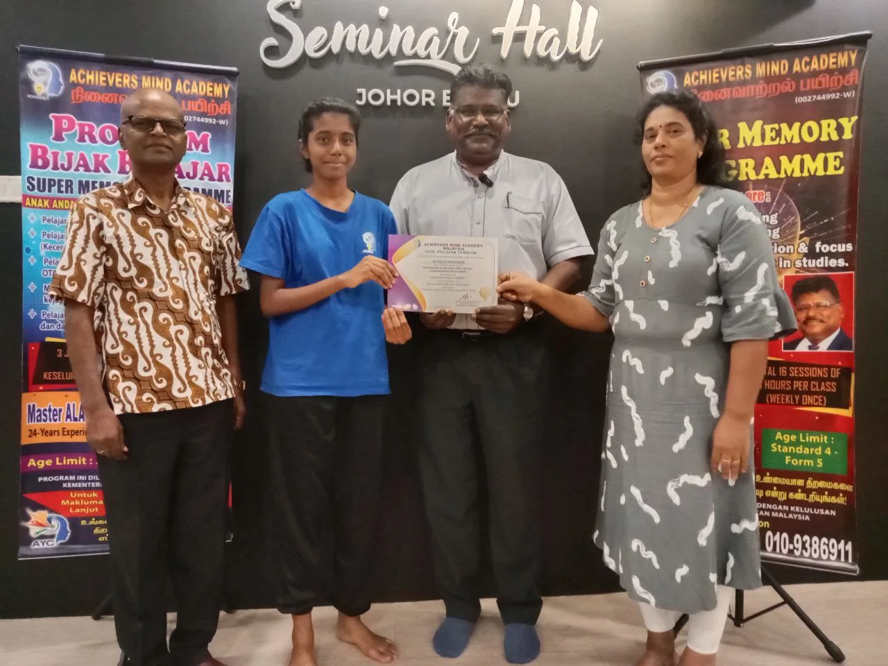 Student recognised beside the Bijak Belajar programme banner